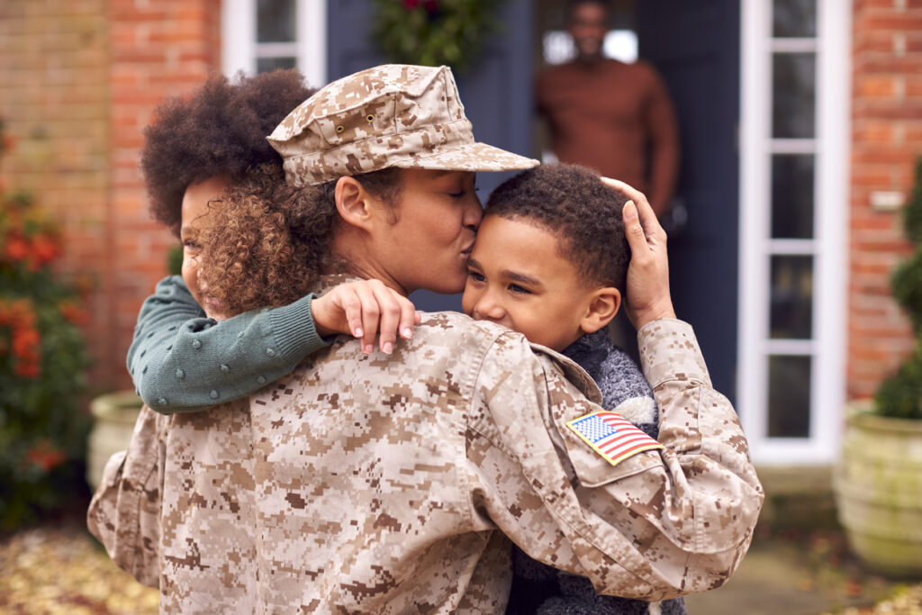 American Female Soldier In Uniform Returning Home To Family On Hugging Children Outside House » MilCon Careers